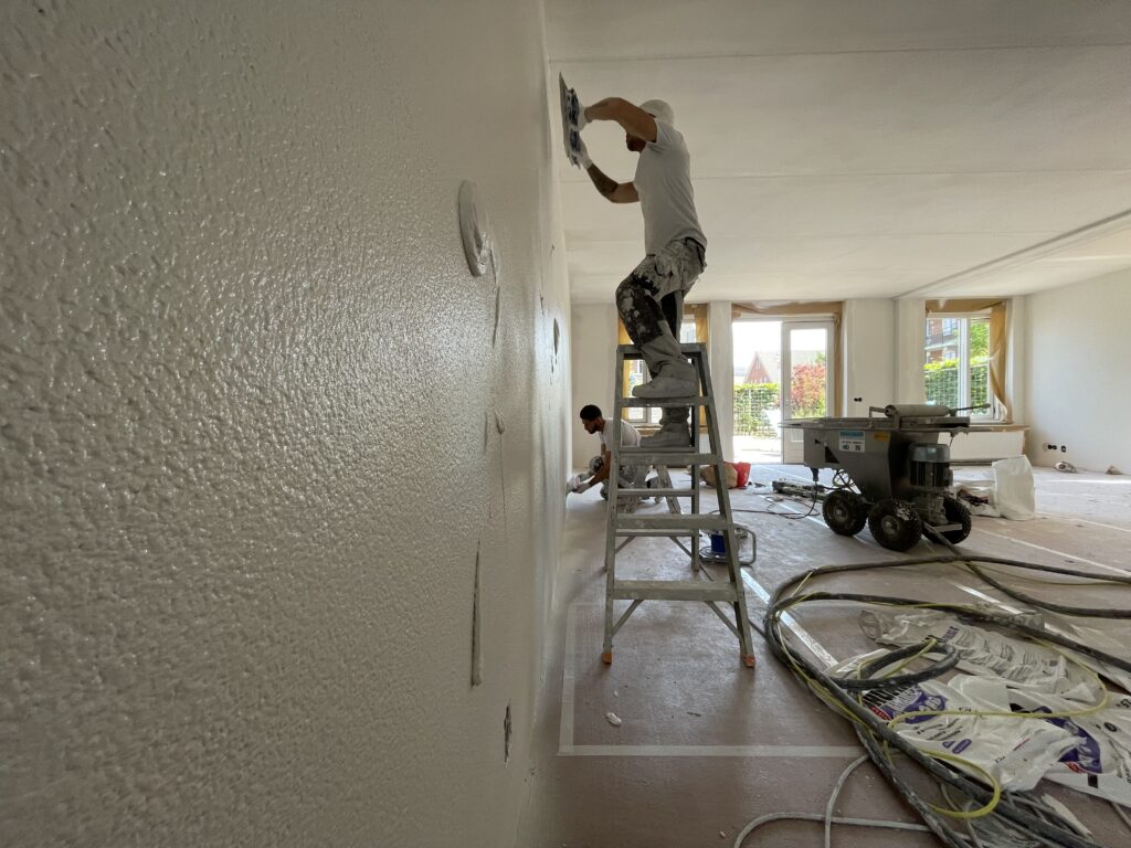 Pleisteren door de verfspuiters