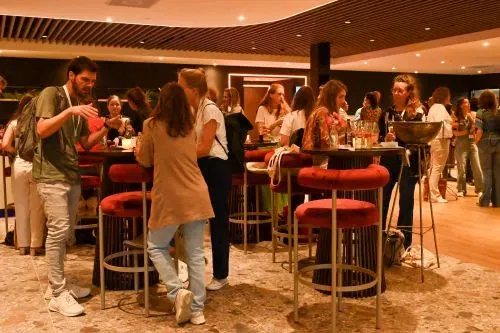 mensen tijdens de borrel aan statafels