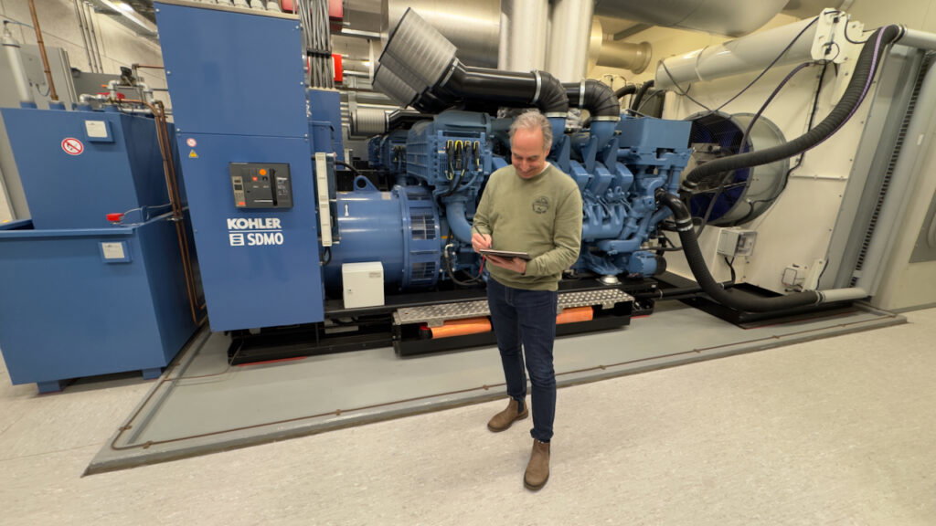 Bert Heskes staat voor grote dieselgenerator