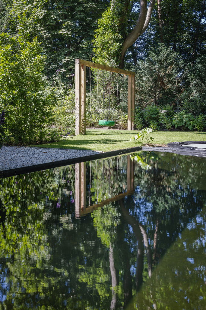 Familietuin met zwemvijver en speeltoestel in tuin