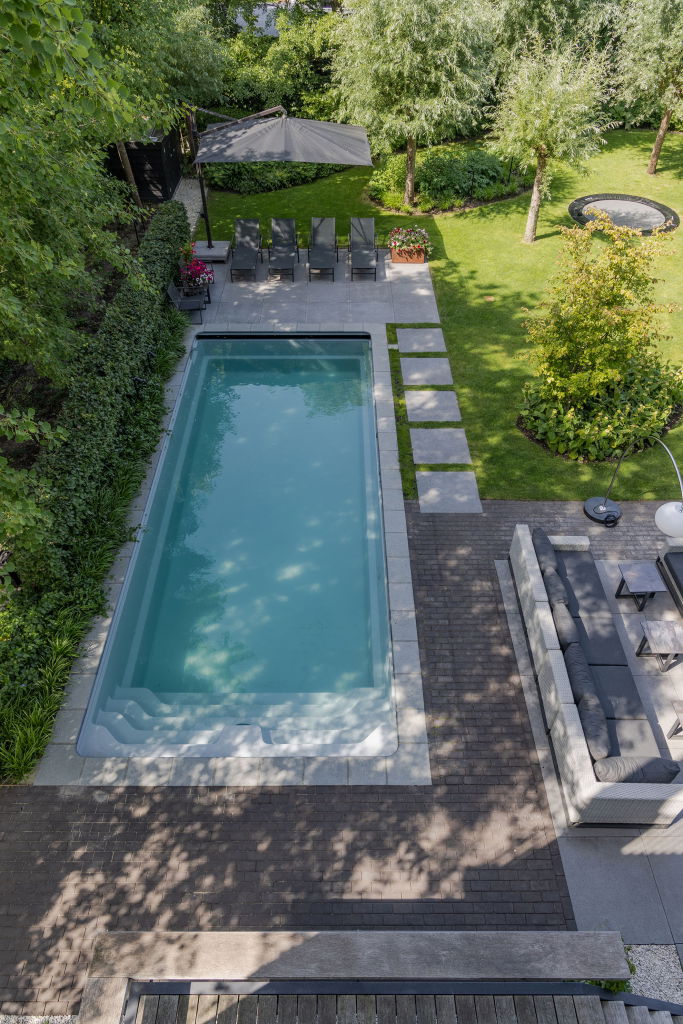 Een luchtfoto van de tuin en het zwembad van bovenaf.