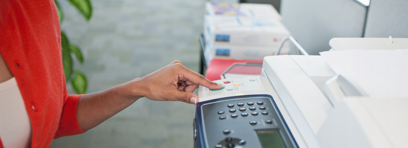 vrouw die een knop op een printer indrukt