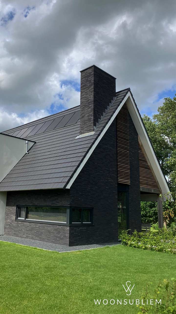 Luxe Schuurwoning levensloopbestendig in Nooitgedacht – Zijaanzicht met robuuste schoorsteen Zijaanzicht van Luxe Schuurwoning levensloopbestendig in Nooitgedacht met hoge schoorsteen en zwarte gevel.