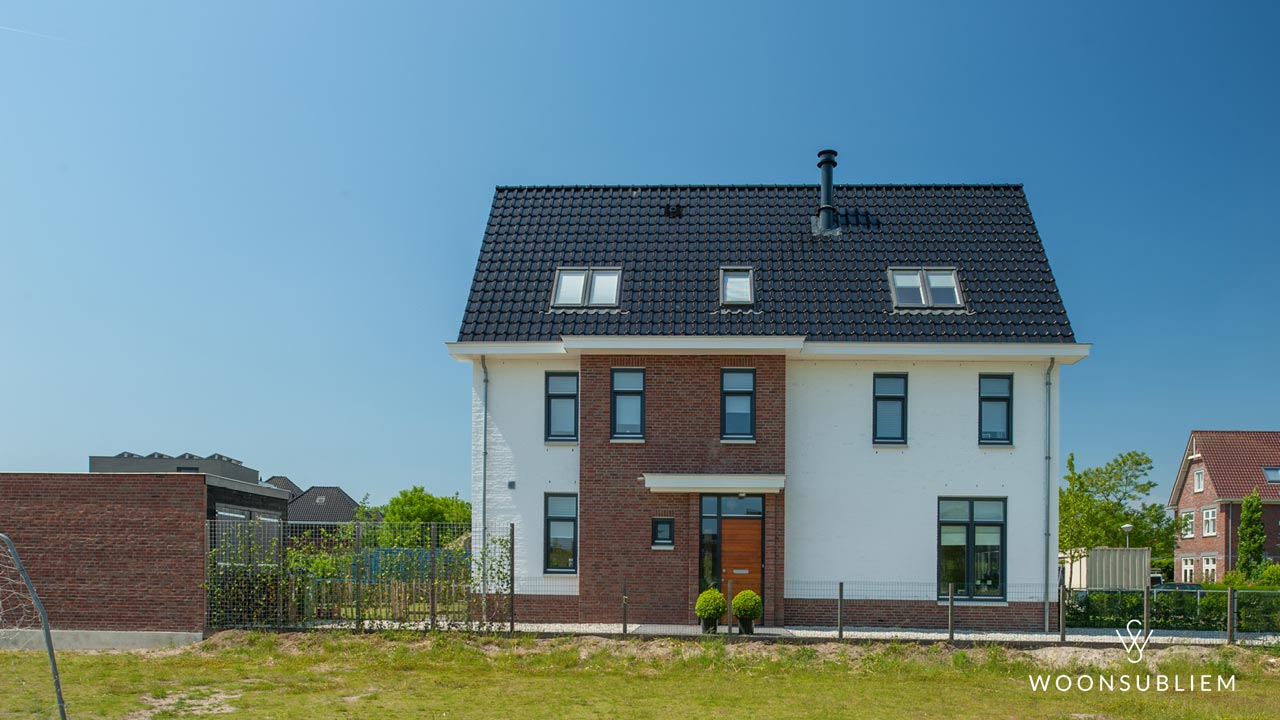 Moderne villa in Woerden met uitgemetselde entreepartij (risaliet) in rood metselwerk en wit gekeimde gevels, ontworpen door WoonSubliem.