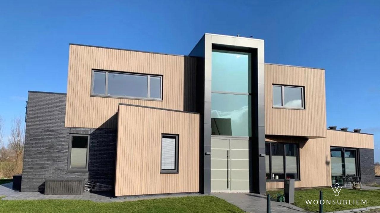 Kubistische woning van WoonSubliem – strak en modern ontwerp met speelse volumes, natuurlijke combinatie van hout en steen, en grote glaspartijen. Ontwerp #220 straalt eigentijdse klasse uit.