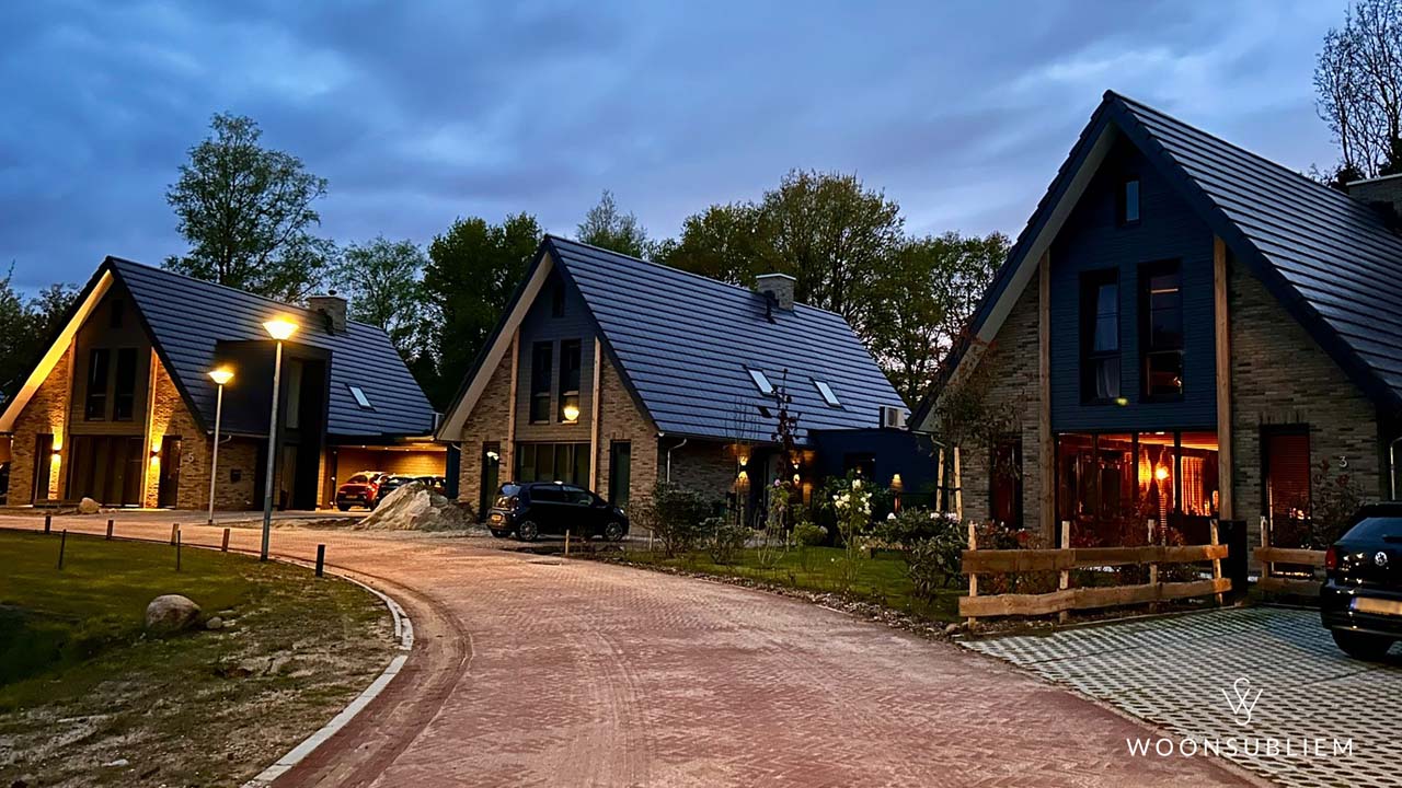 Avondbeeld van schuurwoning voorbeelden in project Vrijheidshof Gieten – drie eigentijdse woningen met donkere kap, eiken accenten en natuurstenen gevels, ontworpen door WoonSubliem.