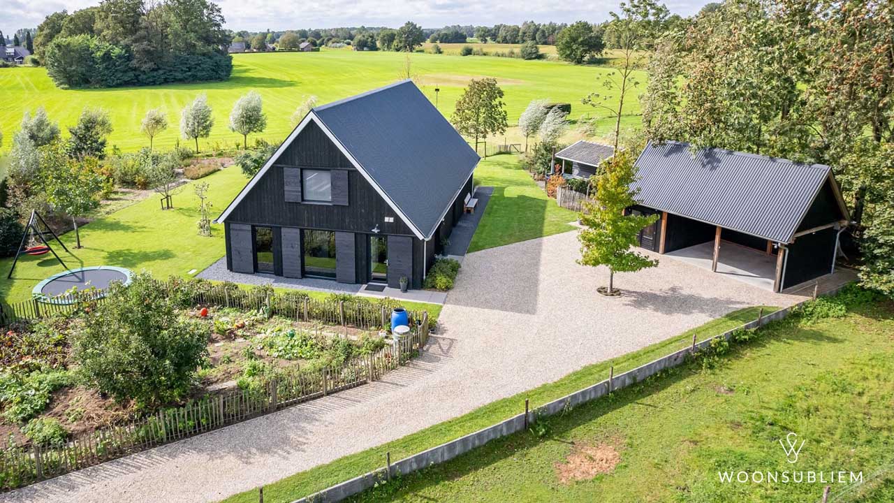 Luxe zwarte schuurwoning met eiken spanten en bijgebouw – landelijke ligging met ruim erf en groen uitzicht.