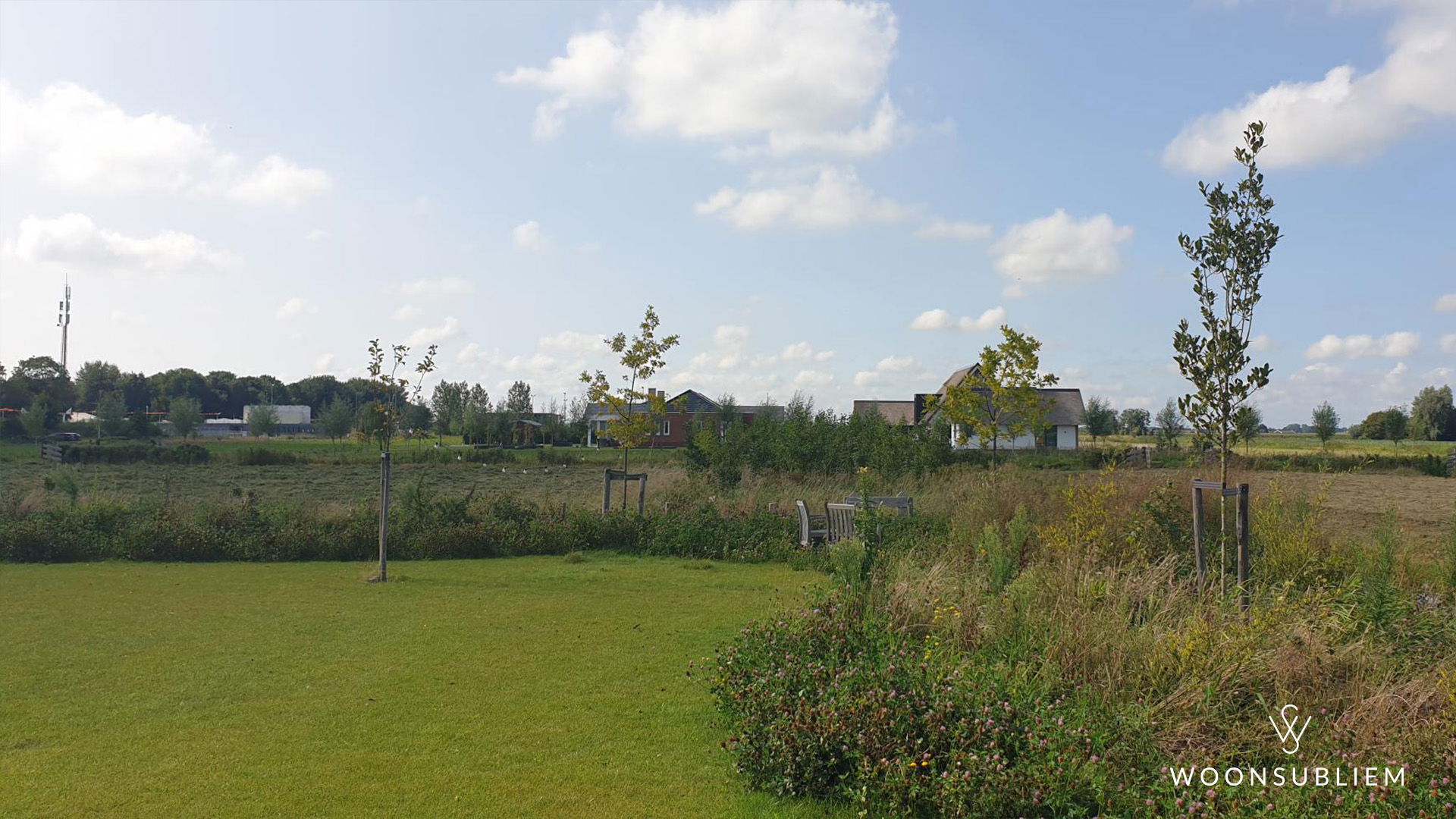Uitzicht op groene kavel met jonge bomen en vrij uitzicht, een van de beste locaties voor een schuurwoning in Nederland.